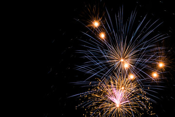 Bright fireworks in the night sky. New year celebration. Copy space.