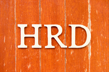 Alphabet letter in word  HRD (Abbreviation of human resource development) on old red color wood plate background