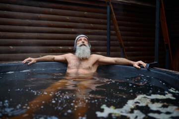 Aged senior man resting in bath outside
