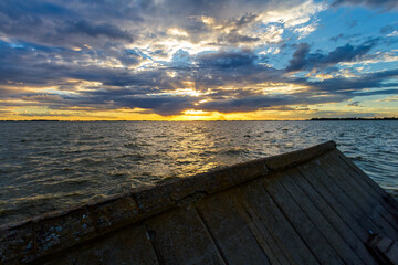 Fototapeta na wymiar Sunset panorama over the Chascomus lagoon (Argentina) with fallen wall