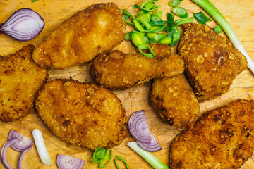 Fried chicken schnitzel on a cutting board. Homemade breaded schnitzel. Fried crispy chicken legs.
