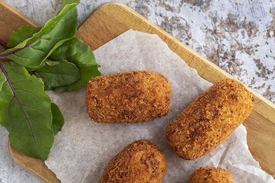 Delicious croquettes with ham on cutting board
