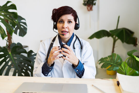 Doctor in headset having online appointment