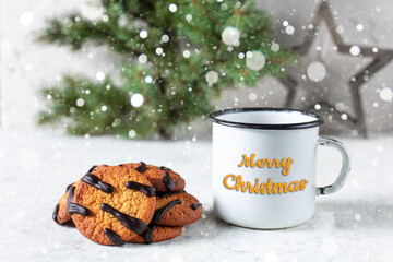 orange cookies with black stripes and cup of tea with fir tree branch. Christmas dessert. Concept for children new year