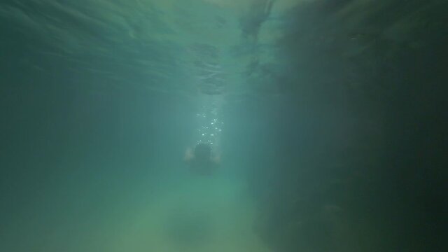 Woman swimming in a cave on Virgin Gorda, slow motion