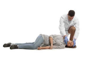 Doctor in uniform practicing first aid on woman against white background