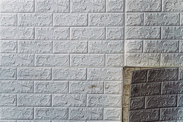 The wallpaper begins to peel off. Old white bricks wallpaper peeled off from the wall inside the room due to moisture or poor quality gluing. Repair and construction services concept. Selective Focus.