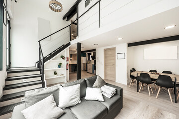 Two-storey loft furnished with metal staircase going up