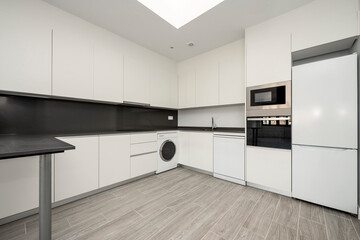 Kitchen with appliances and gray stone countertop in vacation rental apartment