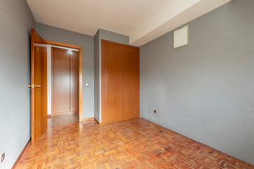 empty room with built-in wardrobe in cherry color and parquet floors