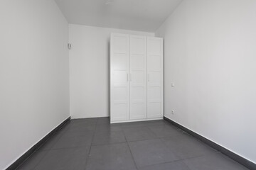 empty bedroom with built in wardrobe in white and gray ceramic flooring