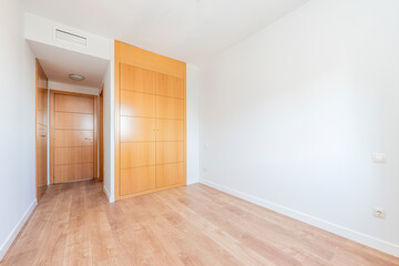 empty room with built-in wardrobe in cherry color and parquet floors