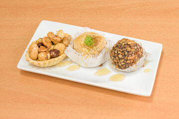 briwats, baklavas, almond blossoms, coconut and almond sulltanas, ghrybas, almond fingers, dried fruit slices with cashew nuts, pastries and chobarkias among others