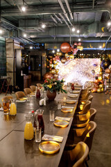 festive table with dining utensils, decorated with New Year's table composition against the background of the restaurant hall in blur