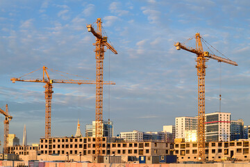 Construction cranes on the construction site of a apartment building on a December afternoon. Saint-Petersburg, Russia