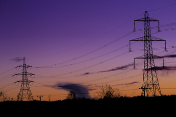 Blue hour shot of pylons silhouetted against the early night sky near Eckington, North East Derbyshire