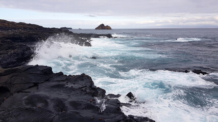Waves crushing against black rocks, Santiago, Galapagos islands