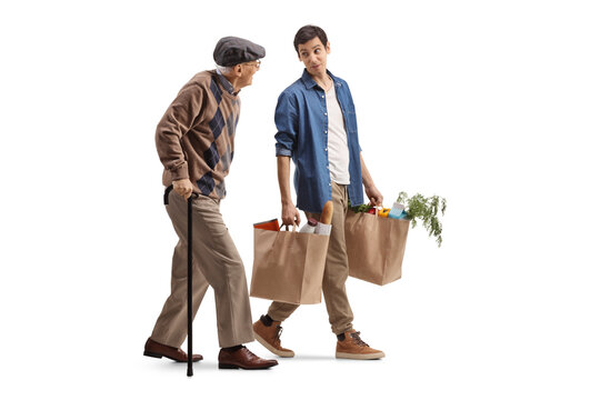 Young man carrying grocery bags and walking with a senior man