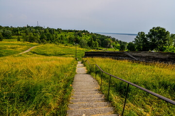 Obraz premium landscape concrete staircase descent to the water against the backdrop of an abandoned bopsleigh track 