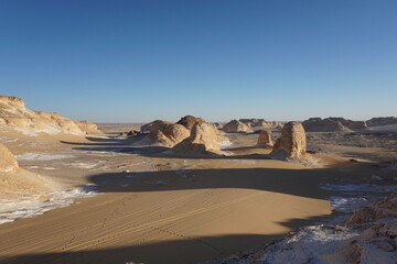 Long shadows of rock formations in the white desert