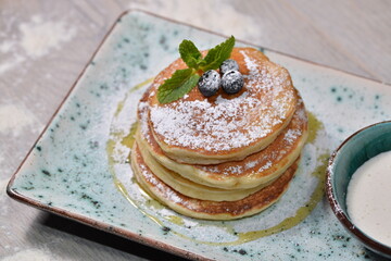 pancakes on a plate covered with sauce decorated with berries
