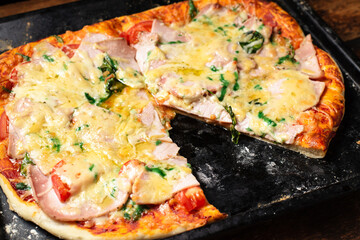 Homemade pizza on a baking sheet. Pizza with sausage, tomatoes, cheese.