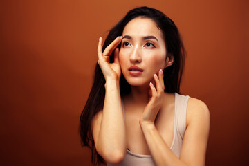 young pretty asian woman cheerful smiling posing on warm brown background, lifestyle people concept