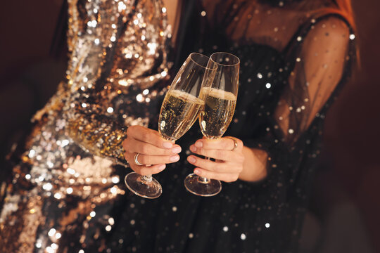 Women with glasses of sparkling wine celebrating New Year indoors, closeup
