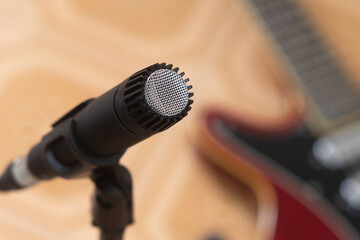 Dynamic microphone with an electric guitar on the background