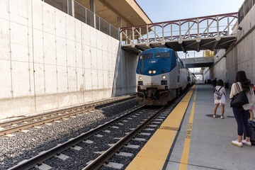 Obraz premium People line up on a platform below ground to board a train