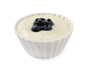 Delicious semolina pudding with blueberries in bowl on white background