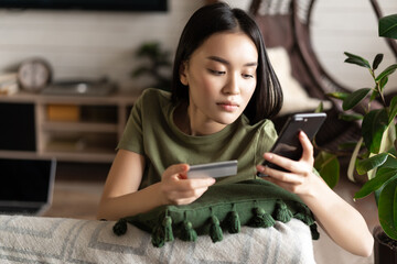 Online shopping. Asian woman purchase online, shopping in application on mobile phone, using credit...