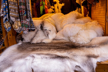 On the counter of the Christmas market are animal skins, warm socks and scarves
