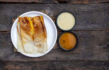 Top View of Masala Dosa Served with Sambhar and Coconut Chutney Isolated on Wooden Background with Copy Space