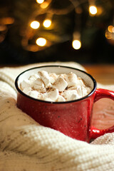 Red mug with cocoa on the background of the Christmas tree