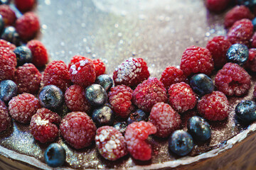part of a round chocolate cake with fresh raspberries and blueberries