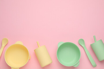 Set of plastic dishware on pink background, flat lay with space for text. Serving baby food