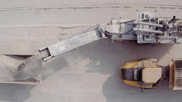 Large excavator in a lignite coal mine. Loading coal into truck. Mining car machinery to transport coal. Open pit mine quarrying extractive industry stripping work. Big Yellow Mining Trucks.