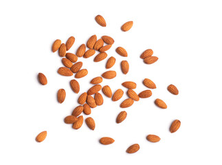 Scattered brown almonds isolated on white background. Close-up view of raw organic nuts. Healthy food for life concept. Vegan and vegetarian tasty snack full of vitamins and oils 