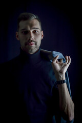 portrait of a young businessman holding his jacket over his shoulder and looking intently in front of him