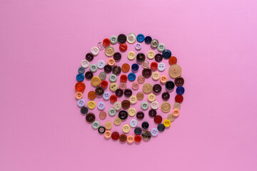 Buttons of various colors and shapes scattered on a white background. Close up. Flat lay.