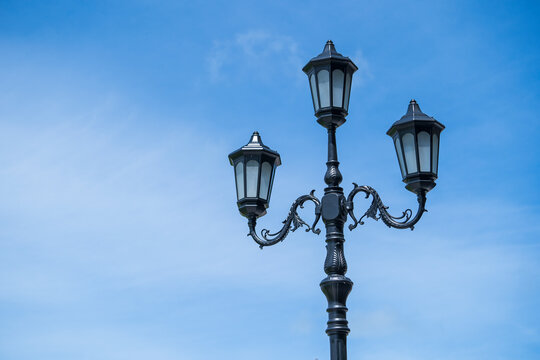 Retro street lamppost against the blue sky background, close up