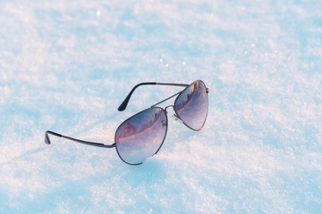 Snow and sunglasses with reflection in them.