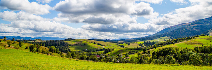 Obraz premium panorama of the countryside in the mountain hills and forests on a warm summer day. The landscape is burning.