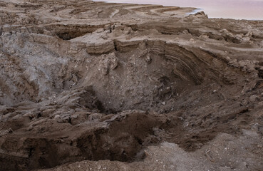 View of Dead Sea sinkholes (or swallows), a deep hole in the ground formed abruptly along the...