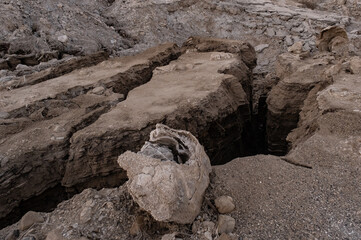 Obraz premium View of Dead Sea sinkholes (or swallows), a deep hole in the ground formed abruptly along the coastline of the Dead Sea, Ein Gedi, Israel. 