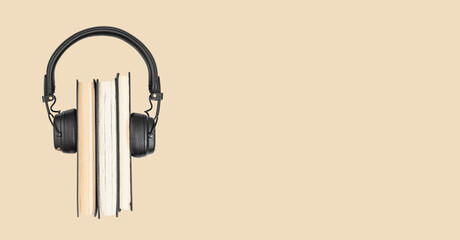 Audio books concept. Classic paper literature stack with headphones. Banner with copy space for text.