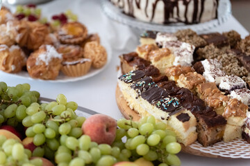 Cakes and fruit on the table. Party food. The table is prepared for a holiday party for guests.