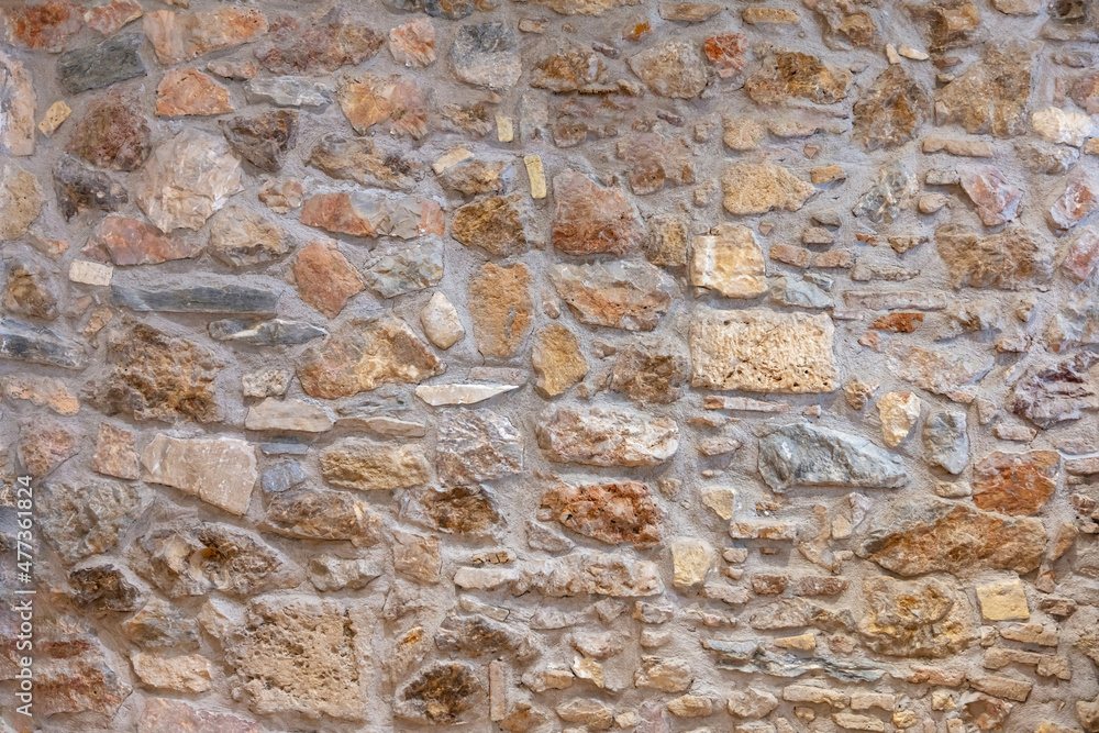 Wall mural Stone wall texture background. Old stonewall traditional pattern building facade, natural material