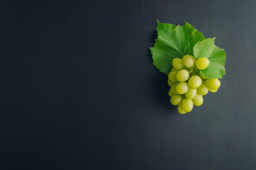Bunches of grapes on dark wood background. Flat lay. Variety of ripe colorful grapes as the symbol...